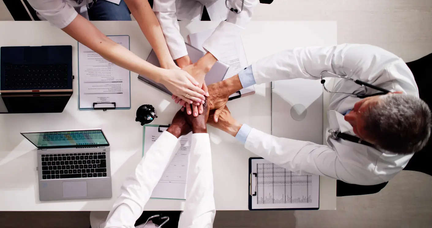 Diverse Medical Team Staff Hands Stack At Desk